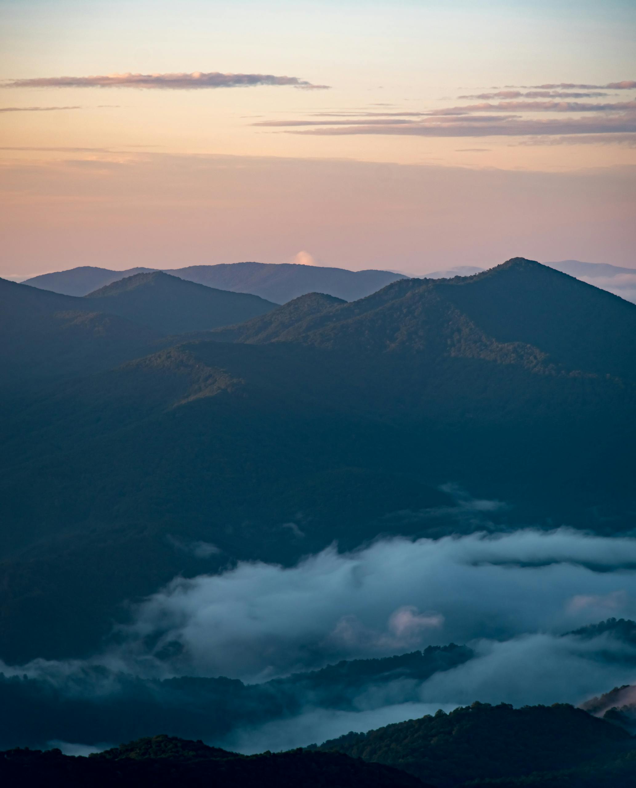 Breathtaking view of Blue Ridge Mountains with fog and twilight sky.